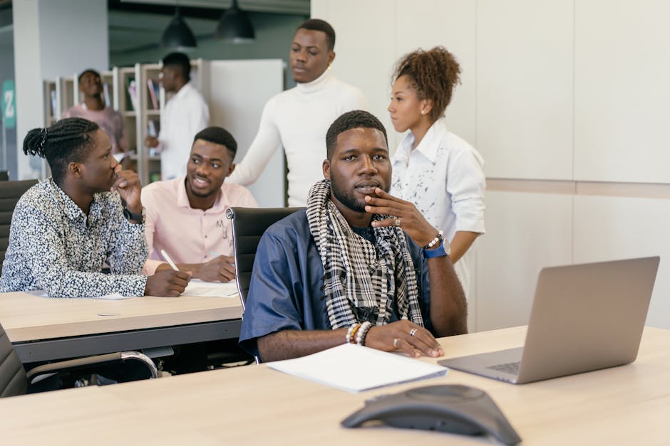 Young professionals collaborating in a modern office setting, focused on teamwork and technology.